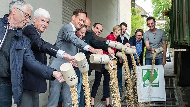 Symbolisch wird die Biogerste für das erste regionale Ökobier gemeinsam von Vertretern des Landkreises und des Projektes mit dem Maßkrug in die Gosse gekippt.  Fotos: Anand Anders