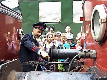Alfred Stöcker zeigt den Kindern, wie die beiden Wagen zusammengekoppelt sind. Foto: Susanne Deuerling