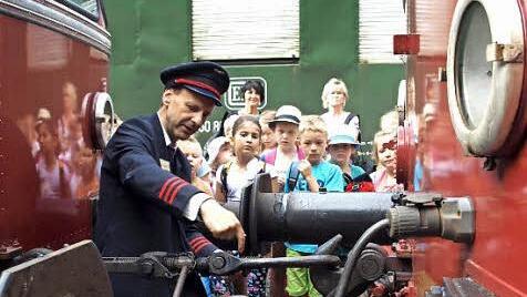 Alfred Stöcker zeigt den Kindern, wie die beiden Wagen zusammengekoppelt sind. Foto: Susanne Deuerling