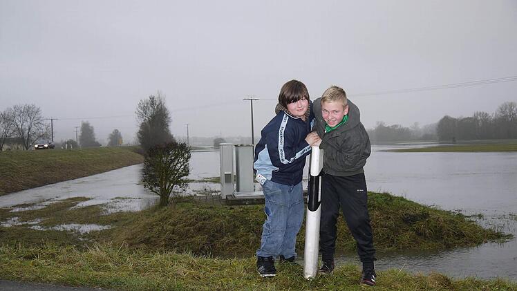 Brave Burschen in der Itzgründer Seenlandschaft: Leon Brüggemann (rechts) und Nico Fertsch waren gestern unweit ihres Heimatortes Gleußen schon wieder dabei, die Spuren des Hochwassers zu beseitigen und stellten einen umgefallenen Straßenpfosten wieder auf.