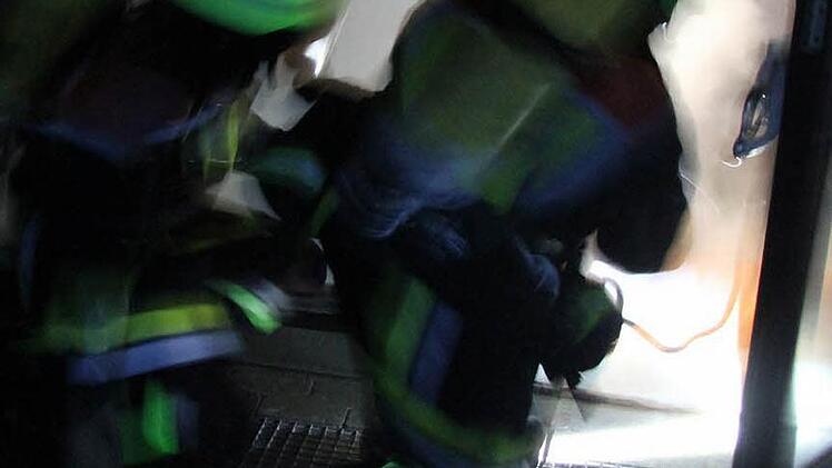 Mit Schwerem Atemschutz stürmen diese Feuerwehrmänner die Schule - immer mit der Leine verbunden.