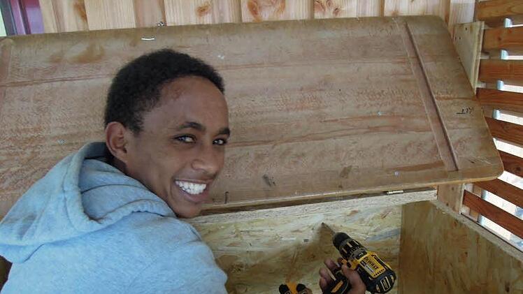Flimon Habtemikael (17) aus Eritrea baut einen Hasenstall.