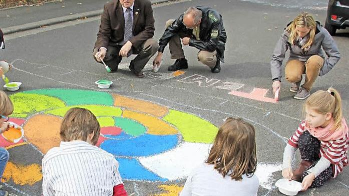 Eine Schnecke pinselten zusammen mit den Kinder Bürgermeister Hennemann, Tobias Kern von der Polizei und Ute Barthelmann, zuständig für Verkehrsrecht im VG-Bauamt (im Bild oben von links), auf die Fahrbahn.  Foto: Ralf Kestel