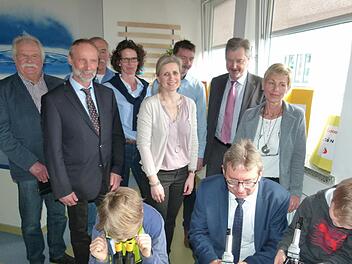 Bürgermeister Wolfgang Bauersachs (vorne Mitte) zwischen zwei experimentierfreudigen Schülern, während die Ehrengäste ihnen über die Schulter schauen (von links): Leonhard Potsch, Hans-Jürgen Marschallek, Werner Hanke, Bettina Klodner-Ochsenreiter, Andrea Sagasser, Michael Rädlein, Werner Löffler und Beate Deuerling. Foto: Lothar Weidner