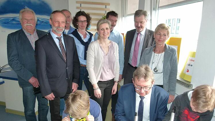 Bürgermeister Wolfgang Bauersachs (vorne Mitte) zwischen zwei experimentierfreudigen Schülern, während die Ehrengäste ihnen über die Schulter schauen (von links): Leonhard Potsch, Hans-Jürgen Marschallek, Werner Hanke, Bettina Klodner-Ochsenreiter, Andrea Sagasser, Michael Rädlein, Werner Löffler und Beate Deuerling. Foto: Lothar Weidner