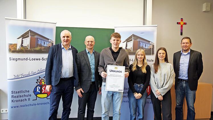 Ministerialbeauftragter Christoph Kasseckert (Zweiter von links) und Beratungsrektor Markus Zenger (rechts) überreichten die Urkunde für herausragende außerunterrichtliche Aktivitäten an den Schulleiter der RS II, Steffen Rost (links) und die Schü...