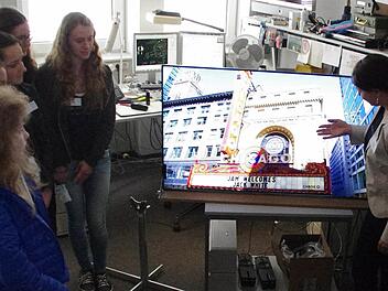 Angela Hofmann (rechts) zeigt den Schülerinnen an einem Hightech-Fernseher, welche Entwicklungen bei Loewe auf den Weg gebracht werden. Foto: Marco Meißner