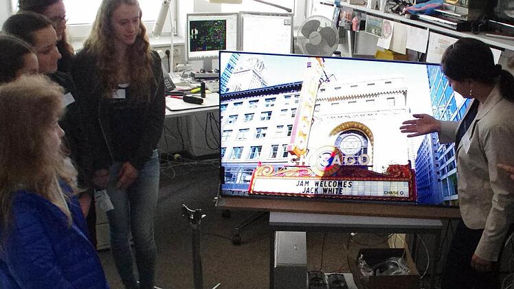 Angela Hofmann (rechts) zeigt den Schülerinnen an einem Hightech-Fernseher, welche Entwicklungen bei Loewe auf den Weg gebracht werden. Foto: Marco Meißner