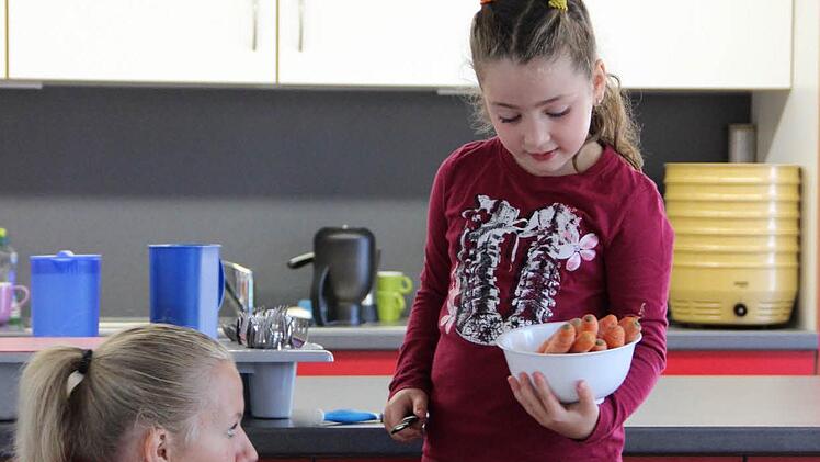 Gemeinsames Essen gehört heute zum Kindergartenalltag. Aurora darf die Möhren schneiden. Foto: Katharina Müller-Sanke