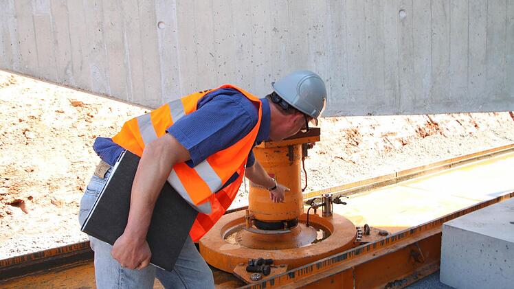 Dirk Groth zeigt den Aufbau es Lastmoduls, das auf verlegbaren Gleitbahnen mittels Gaspolster gleiten kann.
