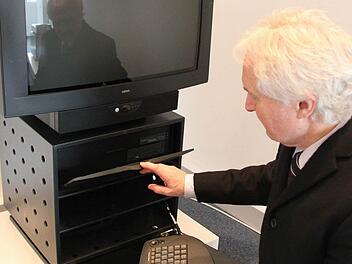 Loewe-Pressesprecher Roland Raithel zeigt den Xelos. Dabei handelt es sich 1995 um den ersten Fernseher, mit dem man im Internet surfen konnte. Im Rack war ein  Computer eingebaut, der über eine Infrarot-Tastatur bedient werden konnte.