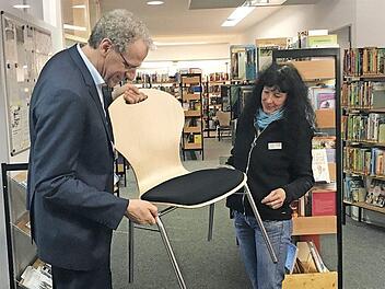 Vor dem Probesitzen wird der Stuhl durch Bibliothekarsleiterin Gabriele Lechner und Bürgermeister German Hacker genau inspiziert.  Foto: Michael Busch