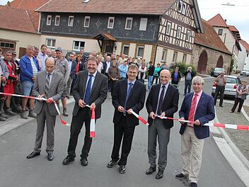 Freigabe: Baudirektor Peter Kraus vom Amt für ländliche Entwicklung, Alfons Schanz, Leiter der Tiefbauverwaltung am Landratsamt in Haßfurt, Bürgermeister Wolfram Thein, Landrat Wilhelm Schneider und Baudirektor Manfred Rott von der Straßenbau-Abteilung im Staatlichen Bauamt in Schweinfurt (im Bild von links) beim Scherenschnitt.