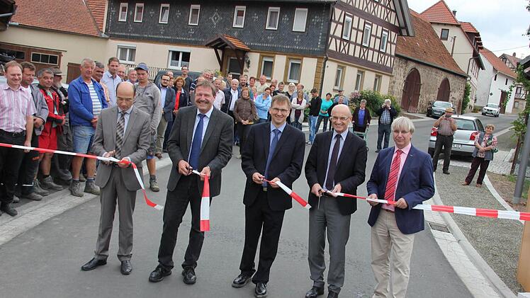 Freigabe: Baudirektor Peter Kraus vom Amt für ländliche Entwicklung, Alfons Schanz, Leiter der Tiefbauverwaltung am Landratsamt in Haßfurt, Bürgermeister Wolfram Thein, Landrat Wilhelm Schneider und Baudirektor Manfred Rott von der Straßenbau-Abteilung im Staatlichen Bauamt in Schweinfurt (im Bild von links) beim Scherenschnitt.