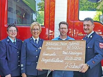 Der Gesch&auml;ftsf&uuml;hrer der B&auml;ckerei Peter Schmitt in Bad Kissingen, Johannes Schmitt (Mitte), &uuml;bergibt den gebackenen Scheck &uuml;ber 500 Euro symbolisch an die Freiwillige Feuerwehr Margetsh&ouml;chheim (von links): 2. Vorsitzende Stefanie N&ouml;th, 1. Vorsitzende Maria Brohm und 1. Kommandant Peter G&ouml;tz.  Foto: Christine Wei&szlig;enberger