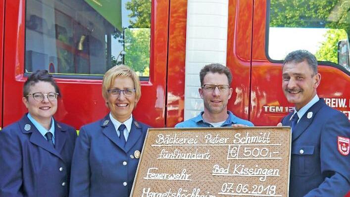 Der Gesch&auml;ftsf&uuml;hrer der B&auml;ckerei Peter Schmitt in Bad Kissingen, Johannes Schmitt (Mitte), &uuml;bergibt den gebackenen Scheck &uuml;ber 500 Euro symbolisch an die Freiwillige Feuerwehr Margetsh&ouml;chheim (von links): 2. Vorsitzende Stefanie N&ouml;th, 1. Vorsitzende Maria Brohm und 1. Kommandant Peter G&ouml;tz.  Foto: Christine Wei&szlig;enberger