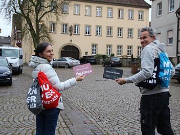 Christine Schikora und Arno Reuscher präsentieren die Rucksäcke und Frühstücksbrettchen des Gewerbevereins.
