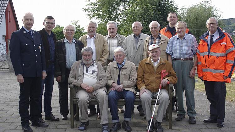 Vereinsvorsitzender Detlef Heim und Bürgermeister Armin Warmuth (von links) sowie KBI Peter Sell und Interimskommandant Edgar Sitzmann (beide rechts) dankten den langjährigen Mitgliedern (sitzend, von links): Heinz Danz, Kilian Werberich und Günther Kress sowie (hinten, von links): Oskar Böhm, Winfried Heim, Herbert Sitzmann, Karl Brandenstein, Leo Hurrlein und Fridolin Oswald. Foto: Winfried Ehling