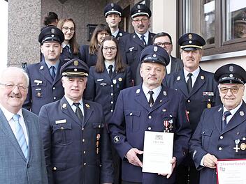 Joachim Hertel (vorne, rechts) wurde zum Ehrengruppenführer ernannt. Georg Barnickel (daneben) wurde für 40 Jahre aktiven Dienst mit dem staatlichen Ehrenzeichen in Gold ausgezeichnet. Mit auf dem Bild sind (vorne, von links) der weitere Stellvertreter des Landrats Bernd Steger, Kreisbrandrat Joachim Ranzenberger sowie Führungskräfte und die weiteren Geehrten. Foto: Michael Wunder