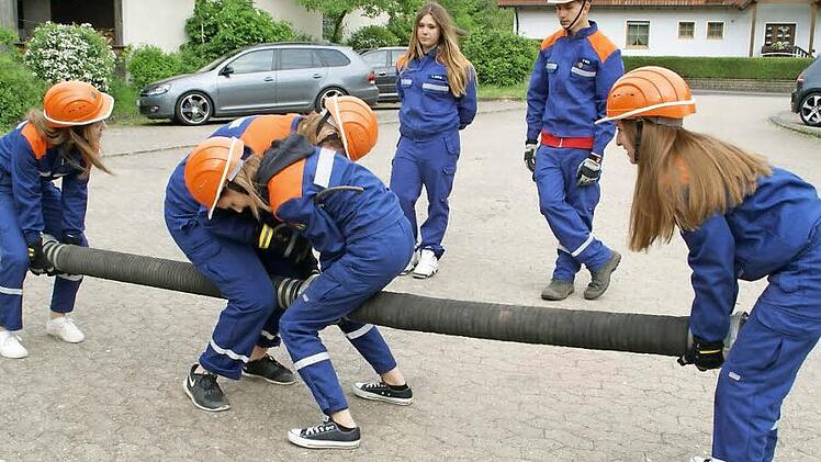 Sie kuppeln die Strahlrohre professionell aneinander: Als einziger Mann unter lauter Feuerwehr-Frauen trat Pascal Weiß (hinten rechts) bei der Jugendfeuerwehr Trossenfurt-Tretzendorf zur Jugendleistungsprüfung an. Fotos: Sabine Weinbeer