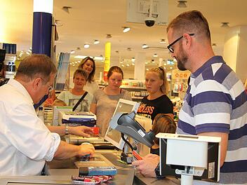 Michael Breitenfelder erstand im dm-Markt Energieriegel für den Urlaub in den Bergen - und noch ein bisschen mehr. Auch eine Überraschung für den Sohn gab es. Oberbürgermeister Henry Schramm konnte schließlich 54,90 Euro kassieren. Fotos: Sonja Adam