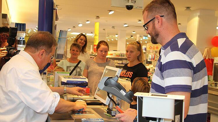 Michael Breitenfelder erstand im dm-Markt Energieriegel für den Urlaub in den Bergen - und noch ein bisschen mehr. Auch eine Überraschung für den Sohn gab es. Oberbürgermeister Henry Schramm konnte schließlich 54,90 Euro kassieren. Fotos: Sonja Adam