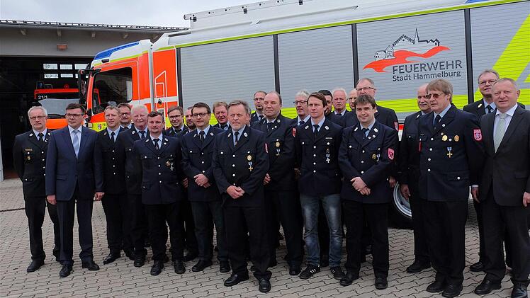 Rund 30 Geehrte stellten sich zum Foto vor den neuen Rüstwagen, mit Kreisbrandmeister Elmar Eisenmann und Bürgermeister Armin Warmuth (von links) und Landrat Thomas Bold (von rechts) und Kreisbrandinspektor Harald Albert.  Fotos: Gerd Schaar