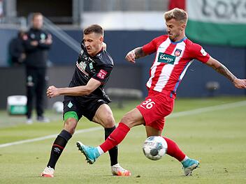 Nach Platz 4 im Vorjahr landeten die Heidenheimer um Niklas Dorsch (rechts) in der 2. Liga diesmal auf dem Relegationsplatz. In zwei Spielen gegen den SV Werder Bremen um Maximilian Eggestein verpasste der Zweitligist aber den Aufstieg.  Foto: Tom Weller/dpa