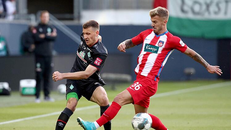 Nach Platz 4 im Vorjahr landeten die Heidenheimer um Niklas Dorsch (rechts) in der 2. Liga diesmal auf dem Relegationsplatz. In zwei Spielen gegen den SV Werder Bremen um Maximilian Eggestein verpasste der Zweitligist aber den Aufstieg.  Foto: Tom Weller/dpa