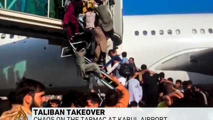 Menschen versuchen in ein Flugzeug auf dem Flughafen von Kabul zu gelangen.