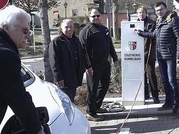 Norbert Kühnl "betankt" das E-Fahrzeug an der ersten Hammelburger Ladestation. Über die Inbetriebnahme freuten sich (von links) Günter Götze, Stefan Collisi, Stadtbaumeister Detlef Mohr und Bürgermeister Armin Warmuth. Foto: Winfried Ehlling