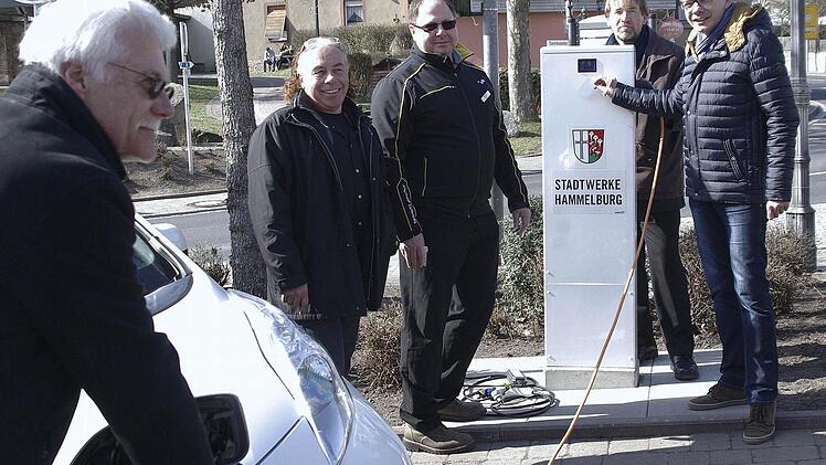 Norbert Kühnl "betankt" das E-Fahrzeug an der ersten Hammelburger Ladestation. Über die Inbetriebnahme freuten sich (von links) Günter Götze, Stefan Collisi, Stadtbaumeister Detlef Mohr und Bürgermeister Armin Warmuth. Foto: Winfried Ehlling