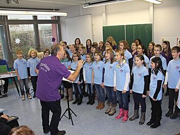 So schwungvoll und dynamisch wie Musiklehrer Bernd Schmidt die Chorklassen 6c und 5c dirigierte, so stimmgewaltig trugen die Kinder ihre Liedbeiträge, bekleidet von Lehrer Heiko Müller am Keyboard (links) vor.  Foto: Helmut Will