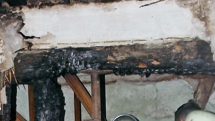 Verbrannte Balken: die Feuerwehr am Brandort