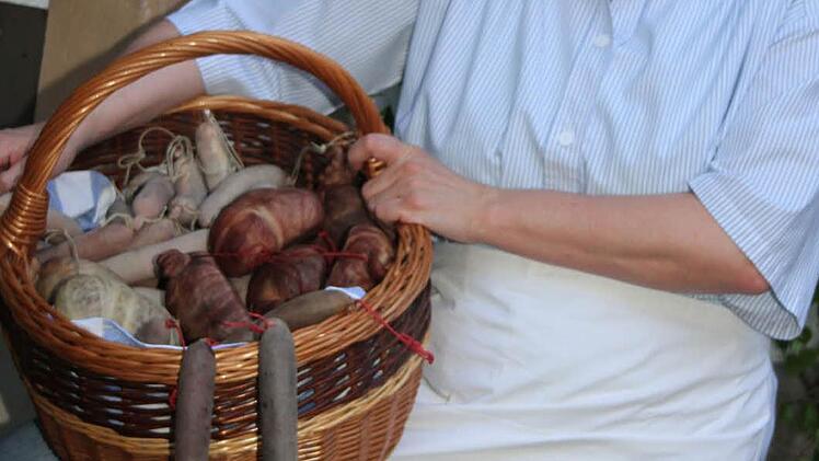 Der Woschdkorb ist richtig schwer. Es ist Tradition, dass alle beim Bauern vorbeikommen und sich ihren Teil abholen.