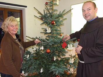 Pater Stanislaus Wentowski und Gitta Biedermann haben den diesjährigen Weihnachtswunschbaum gemeinsam geschmückt, aber es ist noch viel Platz für viele Wunschkärtchen. Foto: Eckert