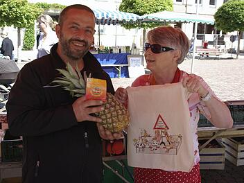 Eine der Ersten, die mit der neuen Einkaufstasche zum "Shoppen" ging, war Eva Albert (rechts). Der Händler Michele Gentile packte ihr eine Ananas auf dem "Grünen Markt" ein.  Foto: Winfried Ehling