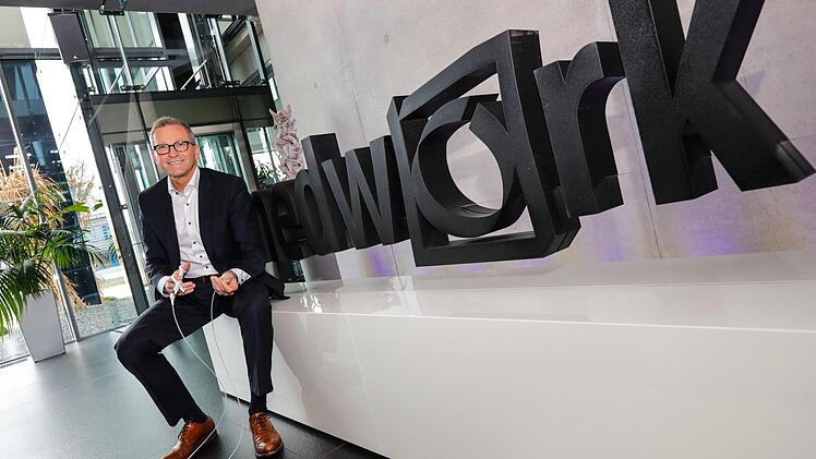 Medwork-Gründer Gerald Fischer vor dem Firmenlogo am Unternehmenssitz Höchstadt Foto: Matthias Hoch