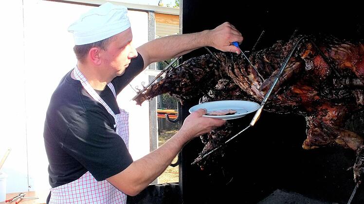 Richard Fösel obliegt immer die Aufgabe, von der "Sau am Spieß" die einzelnen Portionen abzuschnippeln.