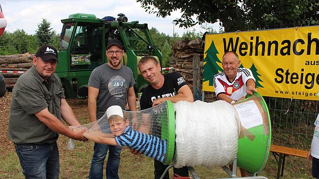Hier k&ouml;nnen Eltern ihre Kinder kostenlos einpacken und mitnehmen, stand auf dem Plakat. Etliche Eltern h&auml;tten vermutlich davon gerne Gebrauch gemacht. Im Bild von links die Besitzer der Christbaumkulturen Dieter Rippel, Christian Be&szlig;ler, Michael Be&szlig;ler und Paul Hennemann, der die B&auml;ume an den Mann bringt. Im Netz der 6-j&auml;hrige Max  Fotos: Evi Seeger
