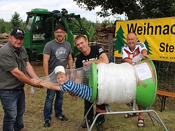 Hier können Eltern ihre Kinder kostenlos einpacken und mitnehmen, stand auf dem Plakat. Etliche Eltern hätten vermutlich davon gerne Gebrauch gemacht. Im Bild von links die Besitzer der Christbaumkulturen Dieter Rippel, Christian Beßler, Michael Beßler und Paul Hennemann, der die Bäume an den Mann bringt. Im Netz der 6-jährige Max  Fotos: Evi Seeger