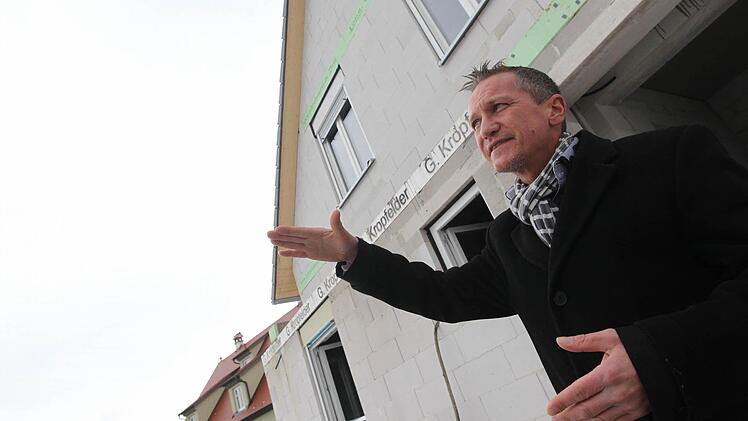 Immobilienmakler Markus Straßburger zeigt vor einem Neubau im Bad Staffelsteiner Ortsteil Unterzettlitz, wohin der Trend geht: nach oben. Foto: Tim Birkner