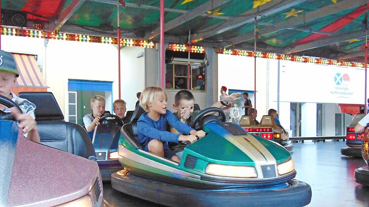 Die Losbude, mit deren Erlösen der Kindergarten unterstützt wird, ist ein traditioneller Treffpunkt auf der Gräfenberger Kerwa (oben). Die Kinder hatten viel Spaß mit den Kerwa-Attraktionen (Fotos unten). Fotos: Petra Malbrich