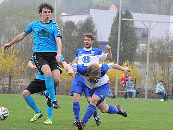 Hoch und tief: In die Luft geht Gerolzhofens Daniel Geck, während der Bad Kissinger Mathis Schneider zum Boden blickt. Den Blick auf den Ball hat einzig Timo Schmitt. Foto: Hopf