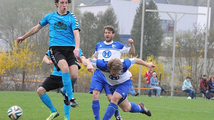 Hoch und tief: In die Luft geht Gerolzhofens Daniel Geck, während der Bad Kissinger Mathis Schneider zum Boden blickt. Den Blick auf den Ball hat einzig Timo Schmitt. Foto: Hopf