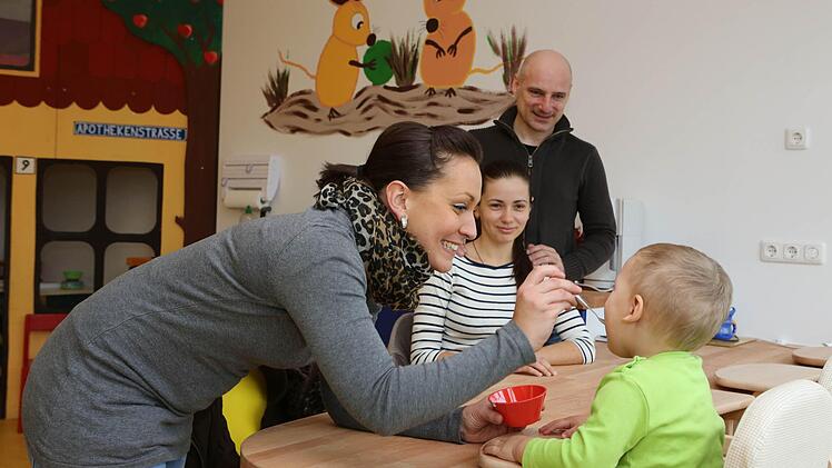 Daniela Kalenyak (vorne) füttert den ersten ,Sonnenkäfer': Alexander, der Sohn von Inna und Jan Braun, lässt sich den Joghurt schmecken.