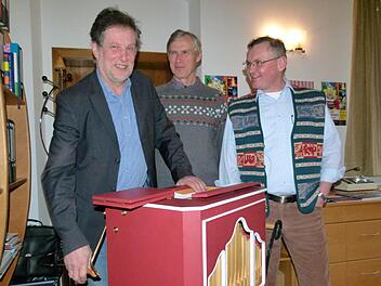 Emil Hartmann (links), Gesamtleiter des Don Bosco Jugendwerks Bamberg, erprobt mit den Salesianern Josef Hauser und Dieter Putzer (rechts) den Leierkasten aus dem Zirkus Giovanni. Foto: Marion Krüger-Hundrup