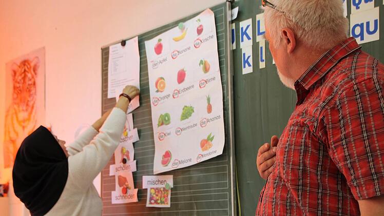 Bernhard Schmitt (rechts) übt mit den Asylbewerbern aus Riedenberg Vokabeln rund um einen Obstsalat. Foto: Ulrike Müller