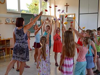 Die Stralsbacher Hügel-Lerchen bei der Probe: Hier singen sie gemeinsam mit Chorleiterin Ganna Kravchenko (links) ein Lied mit Blume und haben auch eine entsprechende Choreografie einstudiert. Am Sonntag werden sie es das erste Mal aufführen.  Foto: Kathrin Kupka-Hahn