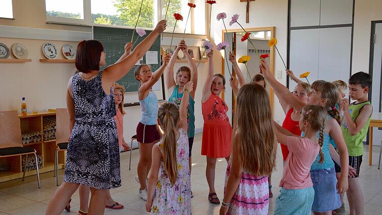 Die Stralsbacher Hügel-Lerchen bei der Probe: Hier singen sie gemeinsam mit Chorleiterin Ganna Kravchenko (links) ein Lied mit Blume und haben auch eine entsprechende Choreografie einstudiert. Am Sonntag werden sie es das erste Mal aufführen.  Foto: Kathrin Kupka-Hahn